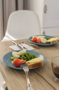 Kimseyle hayat boyu sağlıklı kahvaltı. Tabakta taze biyo-sebze ve sandviç.