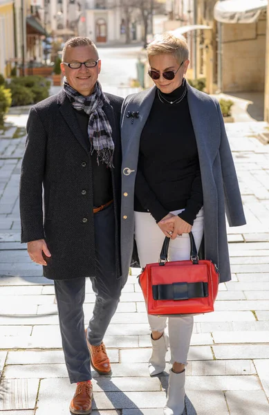 Alegre pareja elegante de mediana edad caminando por la calle juntos. Fuertes relaciones familiares —  Fotos de Stock