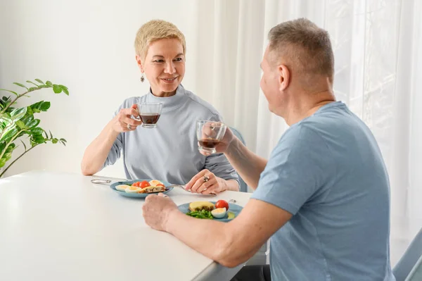 Schönes Senioren-Paar genießt gesundes gemeinsames Abendessen. Sich romantisch anschauen, Tee trinken — Stockfoto