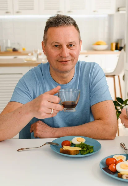 Foto des gesunden älteren Mannes positives Lächeln haben Abendessen in der Küche — Stockfoto