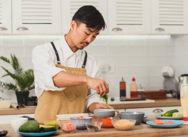 Asyalı şefin portresi. Bambu hasırı ve suşi malzemeleriyle suşi hazırlama.