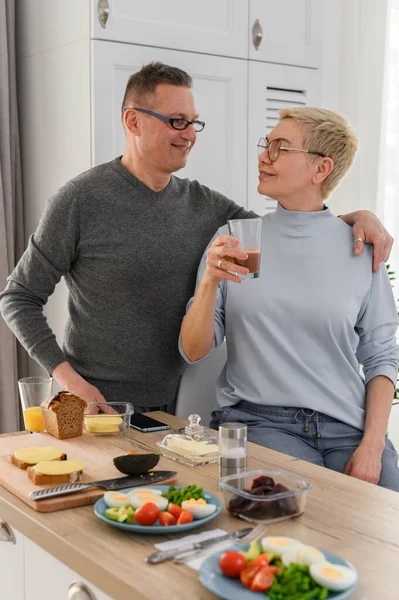 Cheefrul erwachsene Pärchenfamilie essen zu Hause zu Mittag, umarmen und schauen einander. Liebeskummer — Stockfoto