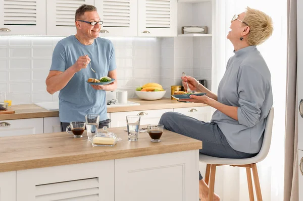 Glückliches reifes Paar beim gemeinsamen Frühstück. Reden und lachen. Guten Morgen im Ruhestand — Stockfoto