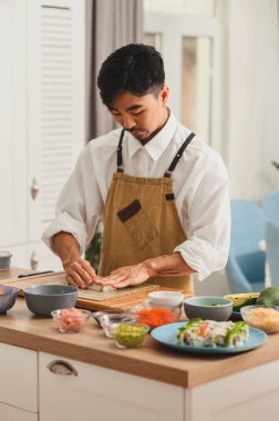 Şef suşi için pilav alıyor. Suşi yapmak için malzemeleri hazırlıyorum. İnternetten yemek servisi. Japon mutfağı: ekmek, soya sosu, wasabi. Restoranın tanıtımı.