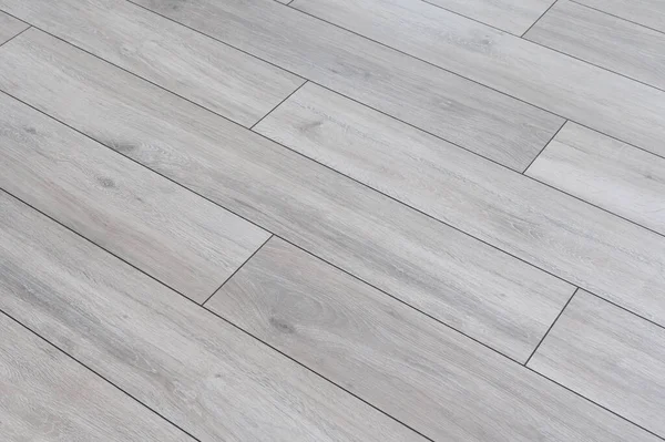 Grey laminate floor texure background. Concept of finishing of houses and apartments. Redecoration in the house