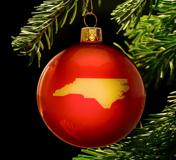 Red bauble with the golden shape of North Carolina hanging on a — Stockfoto