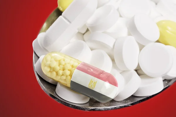 Cucchiaio pieno di pillole e una capsula con il design di punta dell'Egitto .( — Foto Stock
