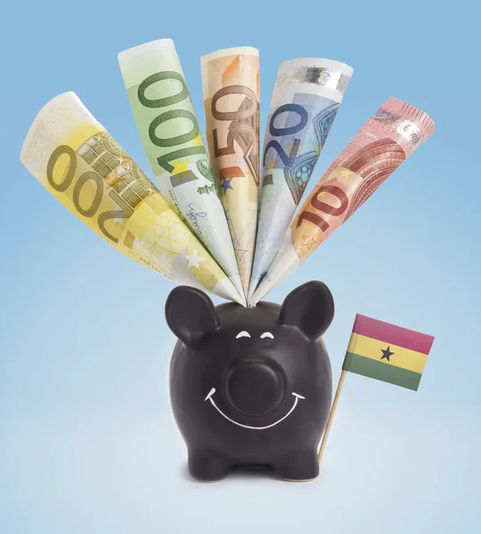 Various european banknotes in a happy piggybank of Ghana.(series — Stock fotografie