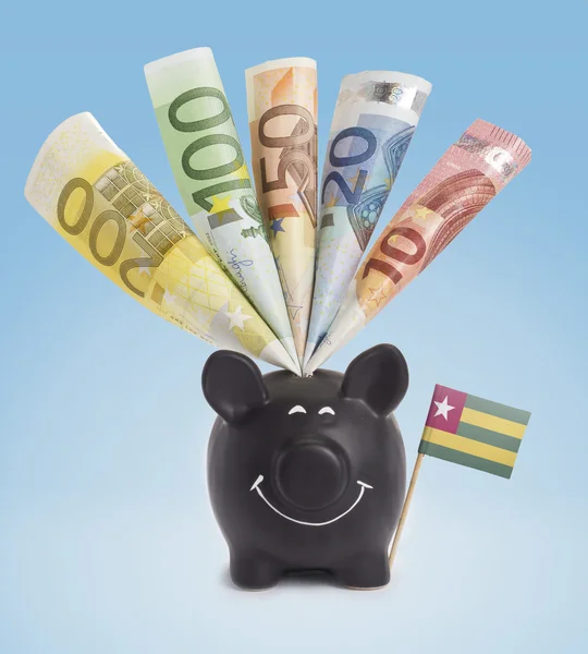 Various european banknotes in a happy piggybank of Togo.(series) — Stock fotografie