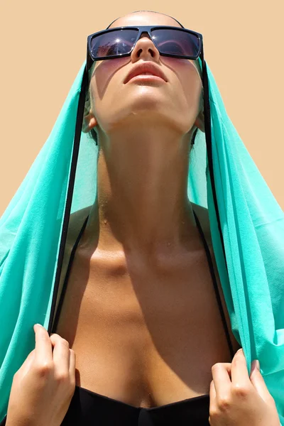 Portret kobiety w czarnym strój kąpielowy okulary przeciwsłoneczne i turkusowa sukienka plażowa stwarza na tle koloru. Modny wygląd. Włosy. Opalona dziewczyna — Zdjęcie stockowe