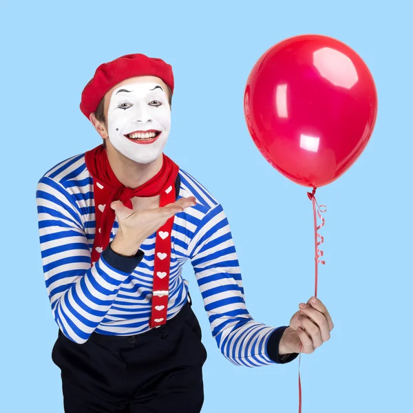 Pantomima s balónem. Emoční legrační herec nošení Učitelská uniforma, červený baret pózuje na modrá barva pozadí. — Stock fotografie