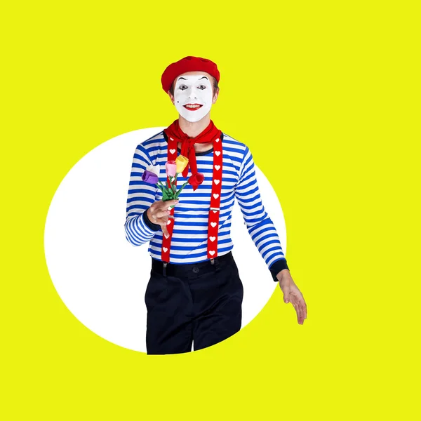 Lächelnder männlicher Pantomime mit Blumen. Lustiger Schauspieler in roter Baskenmütze, Matrosenanzug posiert auf farbigem Hintergrund — Stockfoto
