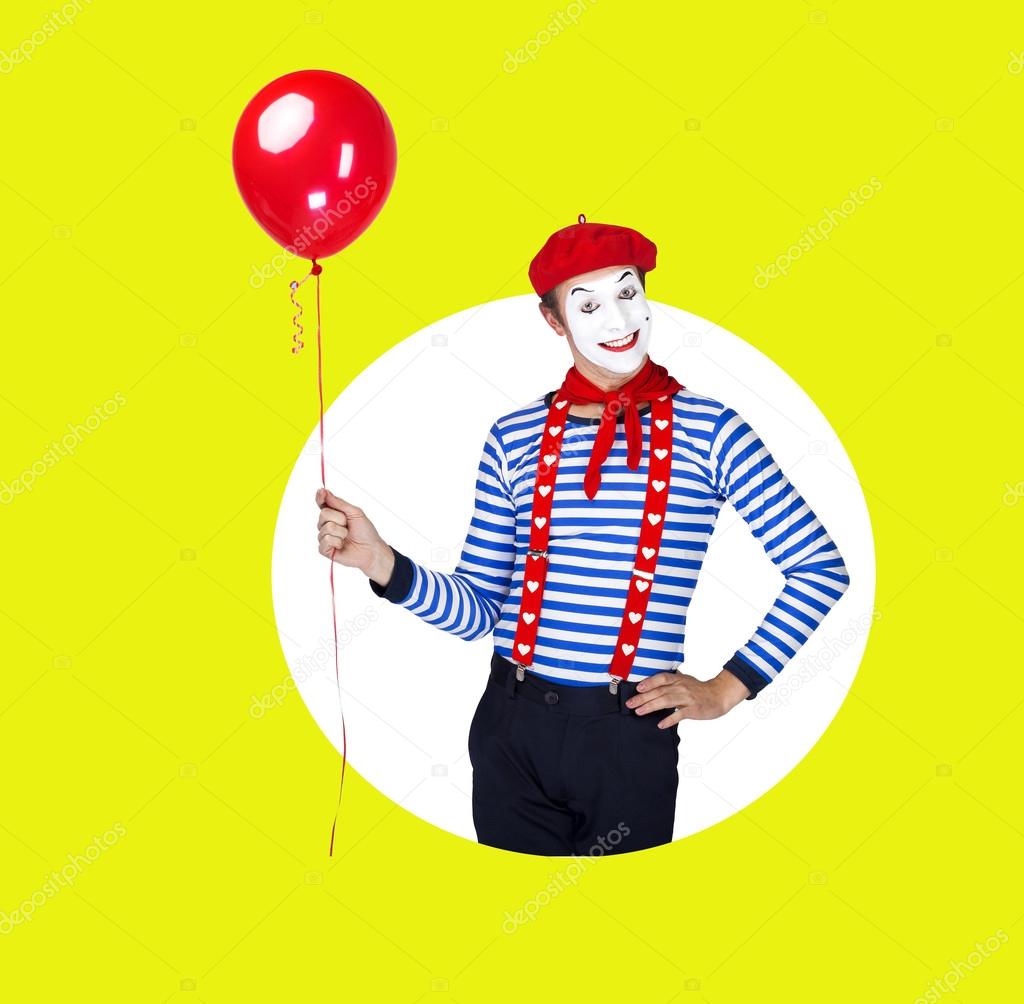 Smiling mime with balloon.Funny actor in red beret, sailor suit posing on color background