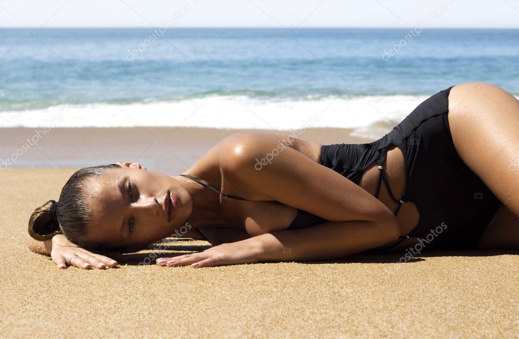 Fashion beautiful woman in bikini lying on beach near sea enjoying looking view of tropics. Hot summer day. Wet sexy girl.Vacation.Photo from Phuket island. Thailand