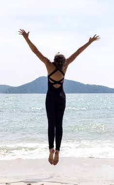 Yoga kadın deniz ve kayalar yakınındaki plajda teşkil etmektedir. Phuket Island, Tayland