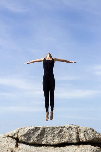 Yoga woman poses on beach near sea and rocks. Phuket island, Thailand