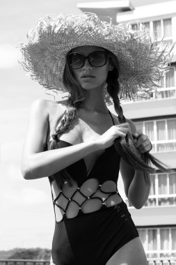 Kadın güneş gözlüğü ve şapka siyah şık mayo pigtails ile peyzaj manzarayı çatıda teşkil etmektedir. Phuket Island, Tayland. Yüksek moda bakmak.