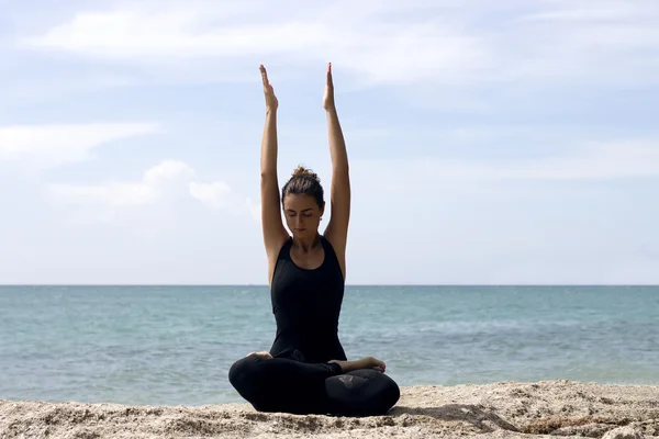 Donna di yoga posa sulla spiaggia vicino al mare e rocce. Isola di Phuket, Thailandia — Foto Stock