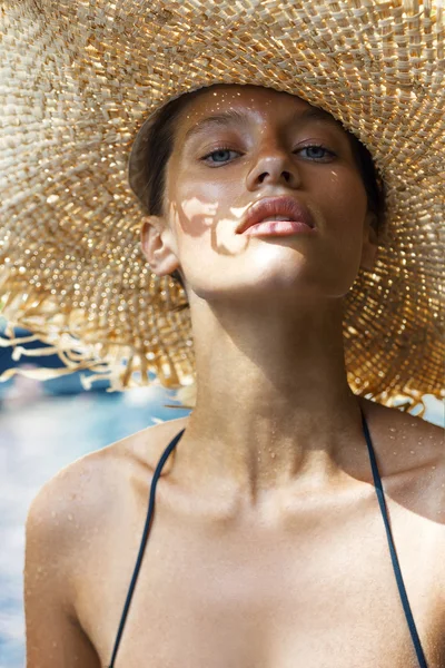 Femme au chapeau et maillot de bain élégant noir pose près de la piscine profitant du soleil. Île de Phuket, Thaïlande. Look haute couture . — Photo