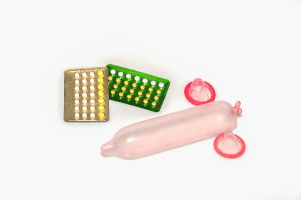 Презервативы и противозачаточные таблетки на белом фоне — стоковое фото