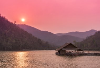 Günbatımı süre sonra nehirde yüzen Sal