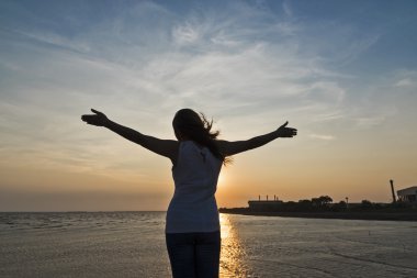 genç kadın Kollarını açarak günbatımında tezahürat 