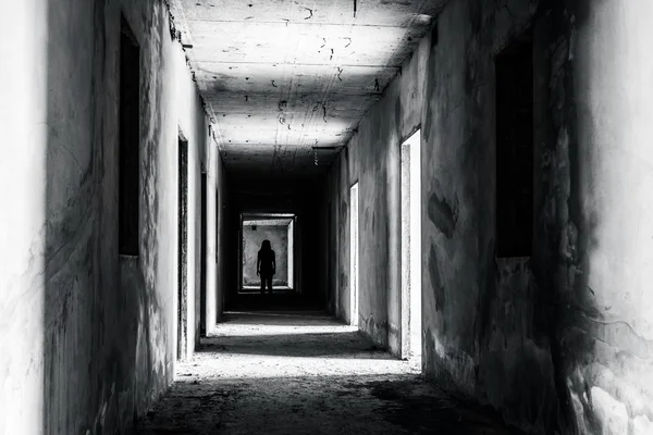 Pasarela într-o clădire abandonată cu o femeie înfricoșătoare în interior — Fotografie, imagine de stoc
