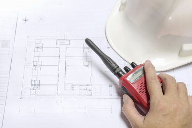 mühendis el telsiz üzerinde mimari bluep tutarak