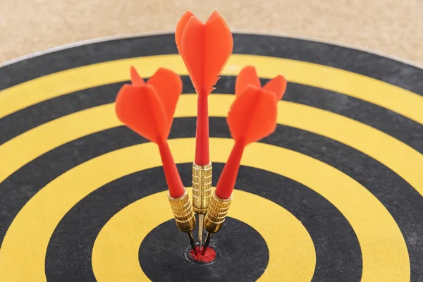 Une cible avec trois flèches de fléchettes frappant le bullseye — Photo