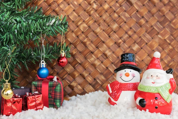 Santa claus a sněhulák v proutěném pozadí — Stock fotografie