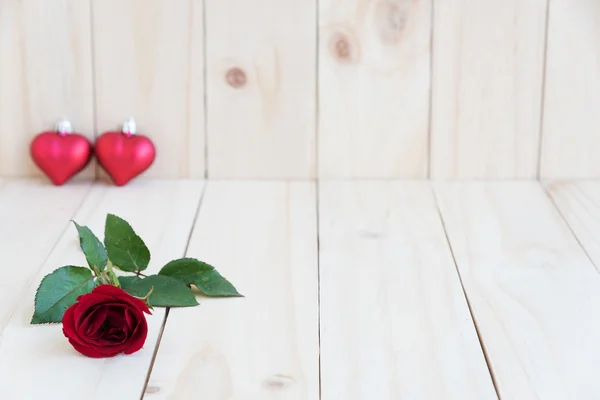 Червона троянда і два серця на дерев'яному фоні — стокове фото