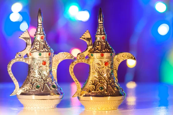 Altın ve gümüş Arapça kahve kap içinde renkli ışıklı geçmiş.