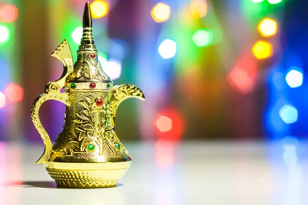 Altın Arapça cezve renkli ışıklı arka planda.