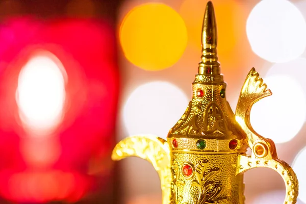 Altın Arapça cezve renkli ışıklı arka planda.