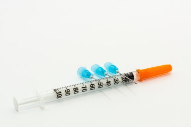 Üç mavi iğne ve bir 1ml tek kullanımlık plastik şırınga