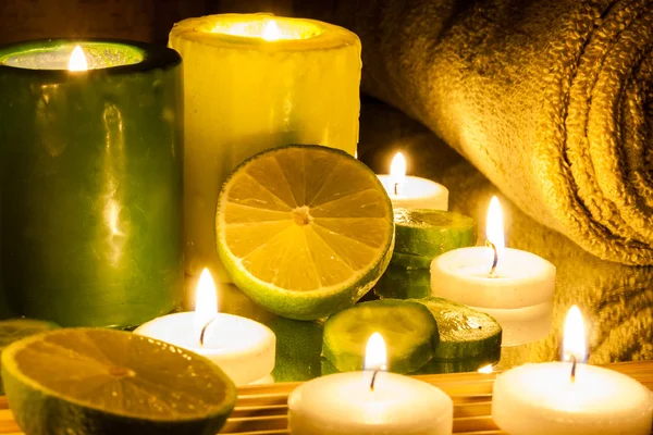 Spa and wellness setting green and yellow candles lit, lemon Green Royalty Free Stock Images