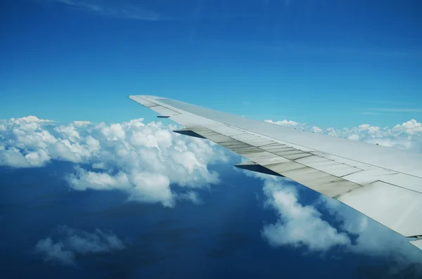 구름 위에 열 대 섬에 도착 하는 비행기의 날개 — 스톡 사진