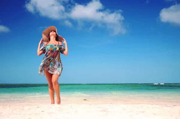 Junge Frau entspannt sich am exotischen Strand und genießt das schöne Wetter Stockbild