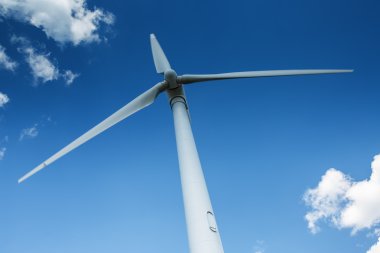 Rüzgar jeneratör türbin karşı derin mavi gökyüzü bulutlu