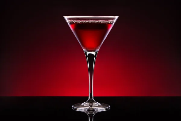 Cóctel de cereza en una copa de cristal aislada sobre fondo rojo negro — Foto de Stock