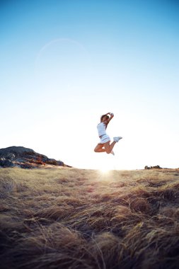 Güzel genç kadın dağ çayır üzerinde atlama