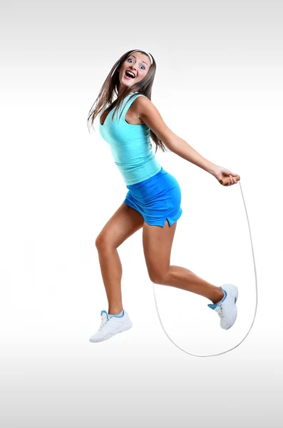 Jovem Happy Girl treinando com corda de salto isolado no branco — Fotografia de Stock