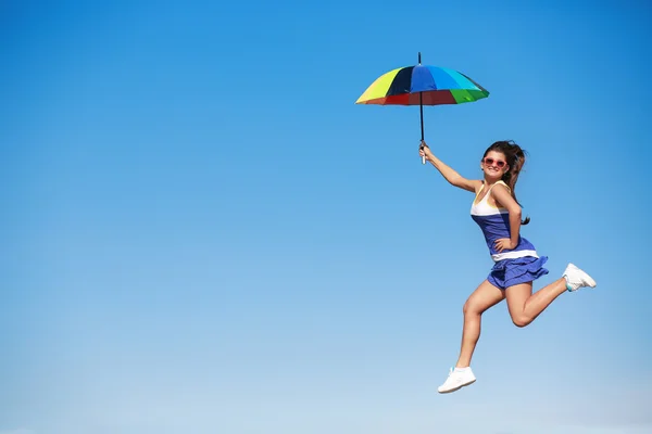 Mladá dívka s deštníkem skákání na obloze — Stock fotografie