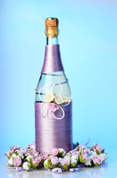 Botella de champán decorada con rosas aisladas —  Fotos de Stock