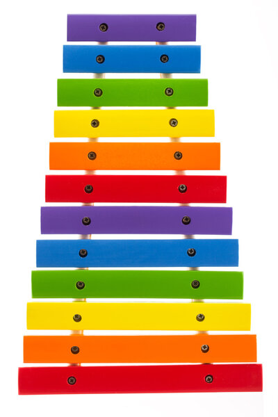 Rainbow colored wooden toy xylophone against white background