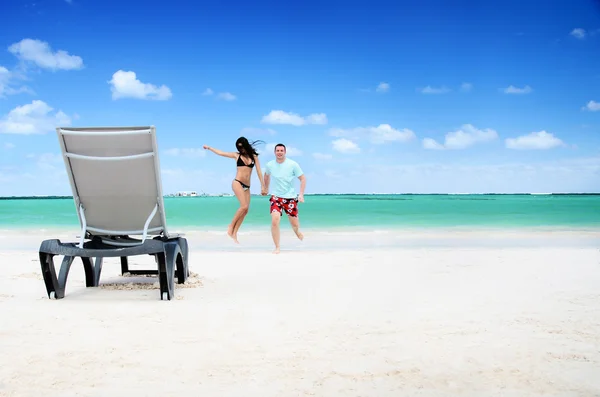 Casal feliz e cadeira em uma praia tropical na República Dominicana — Fotografia de Stock