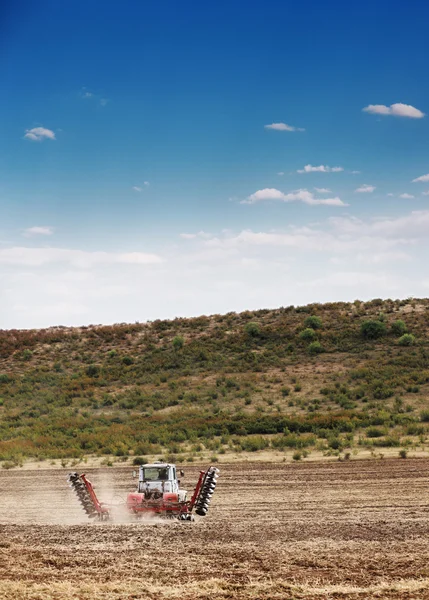 Landschap van een plowing trekker van landbouw op tarwe granen veld — Stockfoto