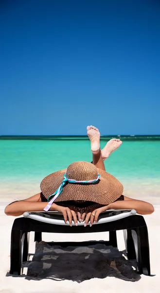 Carefree young woman relaxing on tropical beach — Stock Photo, Image