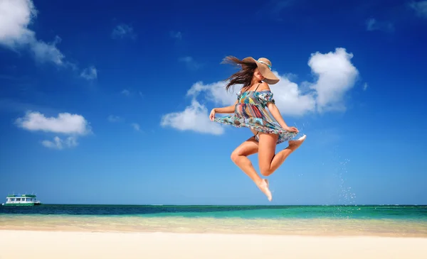 Carefree young woman is jumping into the sky — Stock Photo, Image