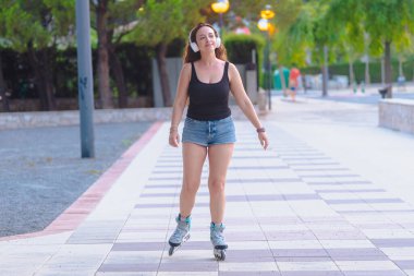 Açık havada bir bankta otururken paten bağlayan, beyaz çorap giyen ve paten seansına hazırlanan, boş zamanları, sporu, fitness 'i, özgürlüğü, enerjiyi temsil eden birinin yakın plan fotoğrafını çekin.